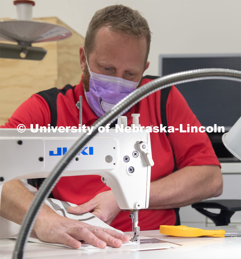 Jerry Reif, shop manager at Nebraska Innovation Studio, cuts hospital gowns from Tyvec material house wrap. The gowns are being assembled for hospitals in Nebraska in response to COVID-19. April 9, 2020. Photo by Gregory Nathan / University Communication.