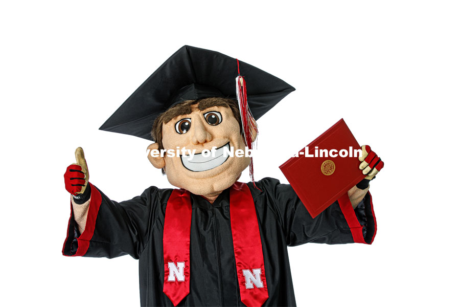 Herbie Husker proudly holds a diploma and is decked out in graduation attire for the Spring Commencement that was which streamed online and aired on NET because of the COVID-19 pandemic. April 10, 2020. Photo by Craig Chandler / University Communication.
