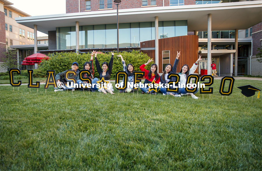 International Students celebrate their graduation outside University Suites on R Street in front of a “Class of 2020” sign. May 8, 2020. Photo by Craig Chandler / University Communication.