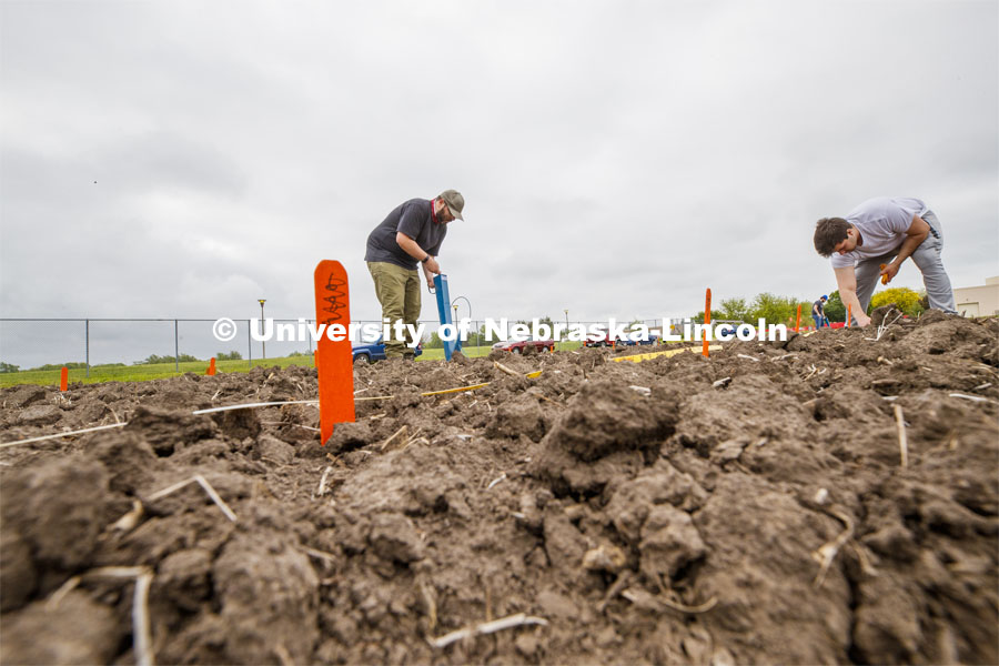 James Schnable operates a hand planter in the freshly tilled soil as Leighton Wheeler, May graduate in biochemistry, places seed packets next to row markers for the next section of planting. East Campus ag fields. May 20, 2020. Photo by Craig Chandler / University Communication.