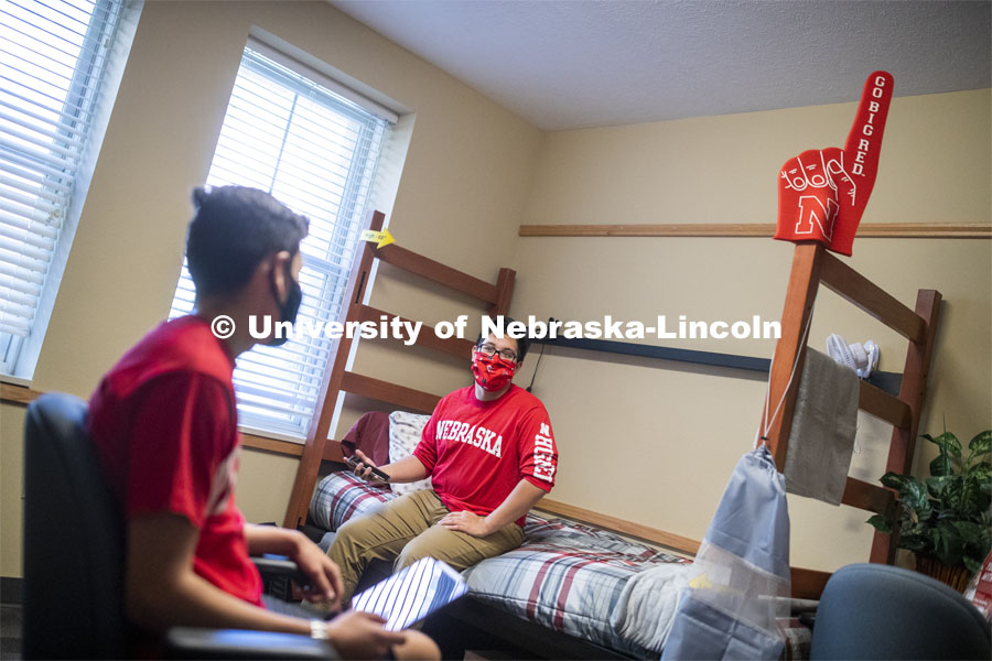 PJ Miguelino talks with Edwin Mendez-Rodriguez in a University Suites Residence Hall room. Photo shoot of students wearing masks and practicing social distancing. June 24, 2020. Photo by Craig Chandler / University Communication.