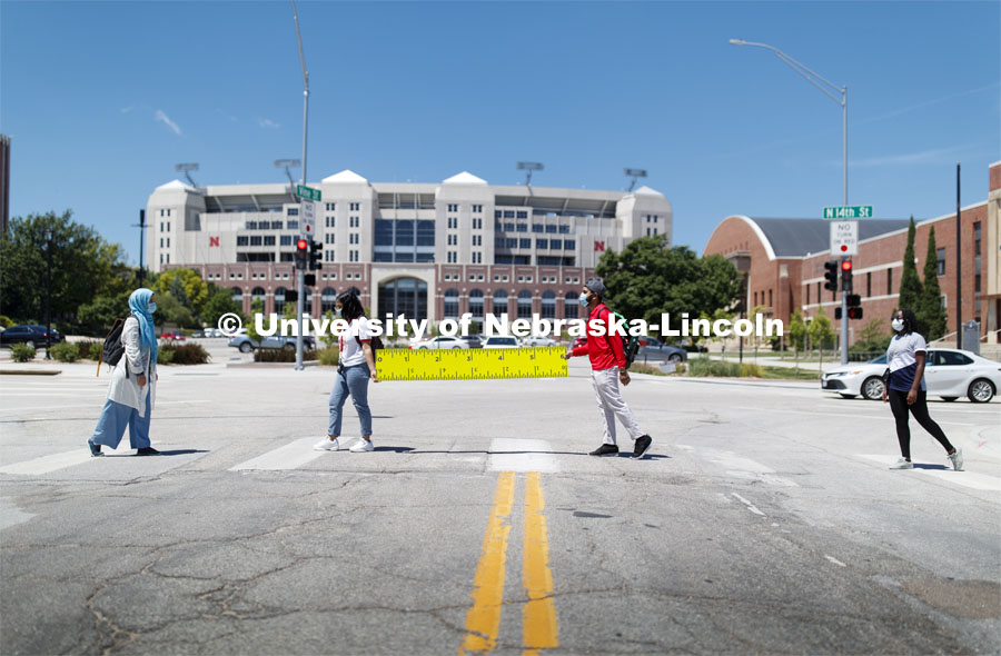 Students at the crosswalk wearing masks with Memorial Stadium in the background. Photo shoot of students wearing masks and practicing social distancing. June 24, 2020. Photo by Craig Chandler / University Communication.
