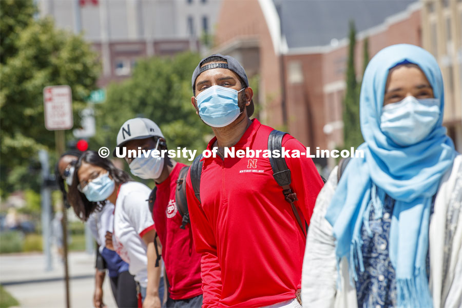 Students are masked up as they wait at the bus stop. Photo shoot of students wearing masks and practicing social distancing. June 24, 2020. Photo by Craig Chandler / University Communication.