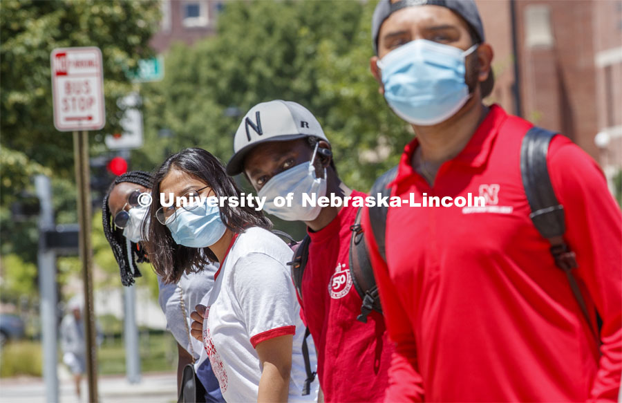 Students are masked up as they wait at the bus stop. Photo shoot of students wearing masks and practicing social distancing. June 24, 2020. Photo by Craig Chandler / University Communication.