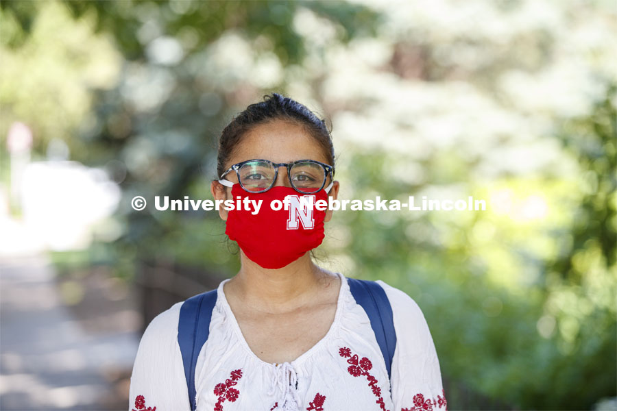 Esha Mishra, graduate student in physics, models the new N mask. More than 60,000 face masks are to be distributed to all students, faculty and staff for the fall semester. June 26, 2020. Photo by Craig Chandler / University Communication.