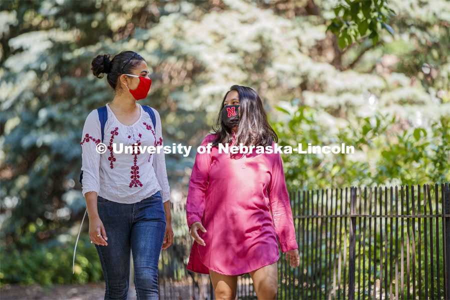 Asmita Jayswal, junior in computer science, and Esha Mishra, graduate student in physics, walk along R Street wearing the new N mask. More than 60,000 face masks are to be distributed to all students, faculty and staff for the fall semester. June 26, 2020. Photo by Craig Chandler / University Communication.