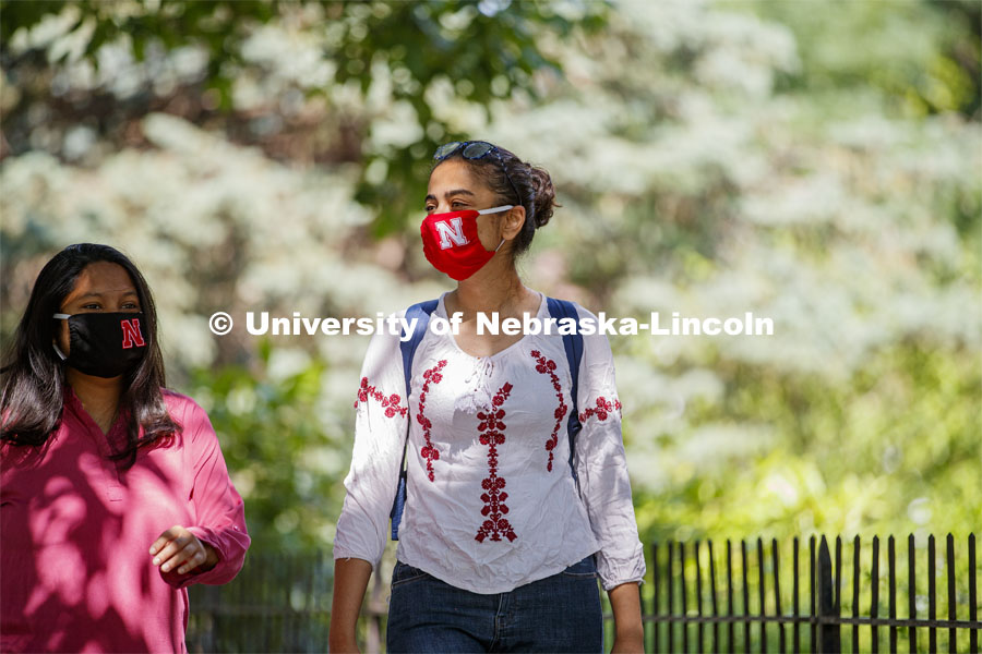 Esha Mishra, graduate student in physics, and Asmita Jayswal, junior in computer science, walk along R Street wearing the new N mask. More than 60,000 face masks are to be distributed to all students, faculty and staff for the fall semester. June 26, 2020. Photo by Craig Chandler / University Communication.