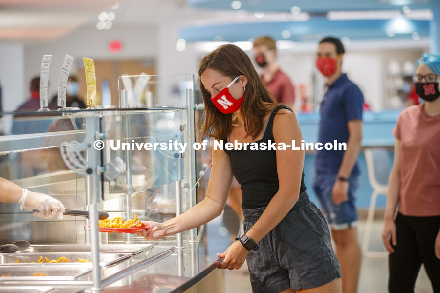 Students selecting food and being served by UNL Dining Staff. Photo shoot of students wearing masks and practicing social distancing in dining services in Willa Cather Dining Center. July 1, 2020. Photo by Craig Chandler / University Communication.