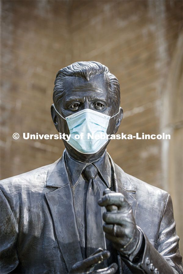 The statue of Clifford Hardin, one of four Nebraskans who served as U.S. Secretaries of Agriculture, models a mask on the University of Nebraska-Lincoln's East Campus. The sculpture is one of many UNL campus sculptures wearing masks. Mask wearing statues on campus. July 6, 2020. Photo by Craig Chandler / University Communication.