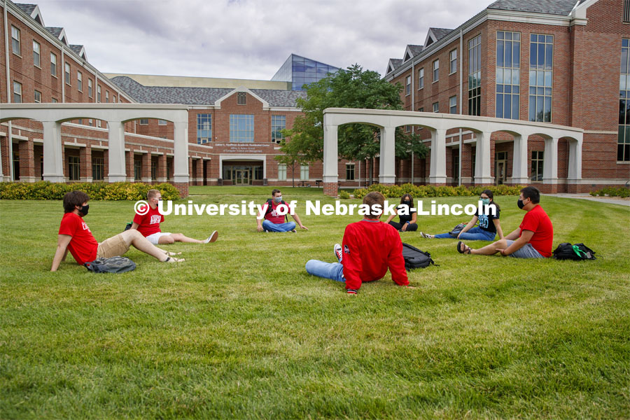 Photo shoot of students on city campus display mask wearing and social distancing. Students lounge on the grass outside Kauffman, all while maintaining a social distance. August 5, 2020. Photo by Craig Chandler / University Communication.