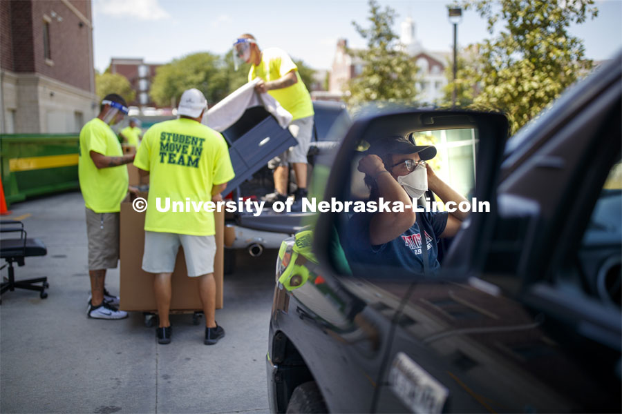 The Student Move-In Team unloads a truck. A student masks up while waiting for his turn to unload at Knoll Residence Hall. First day of residence hall move in. August 13, 2020. Photo by Craig Chandler / University Communication.