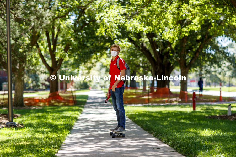 Evan Portz, a junior from Arizona, longboards toward his job at the East Campus student union. First day of classes on UNL campus. August 17, 2020. Photo by Craig Chandler / University Communication.