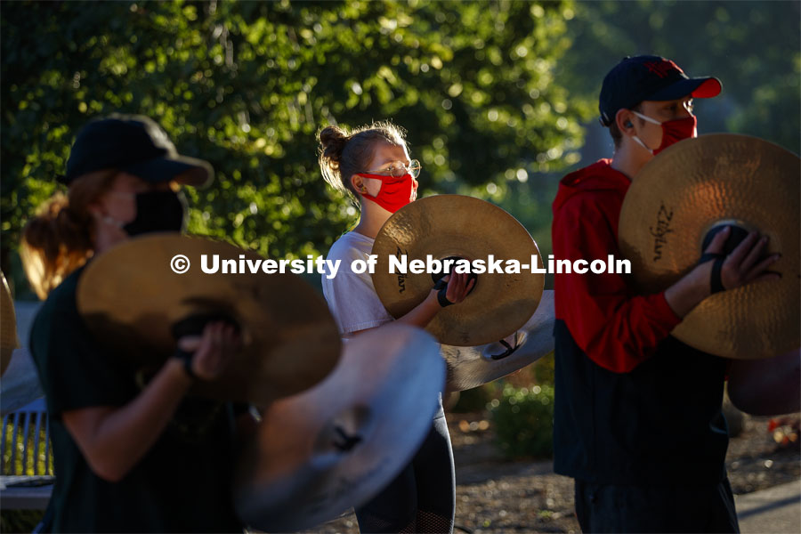 The sunrise reflects off of Skyler Krull's cymbal during the early morning practice. A sunrise serenade as the cymbals and bass line of the Cornhusker Marching Band practices outside Kimball Music Hall Tuesday morning, September 2, 2020. Photo by Craig Chandler / University Communication.