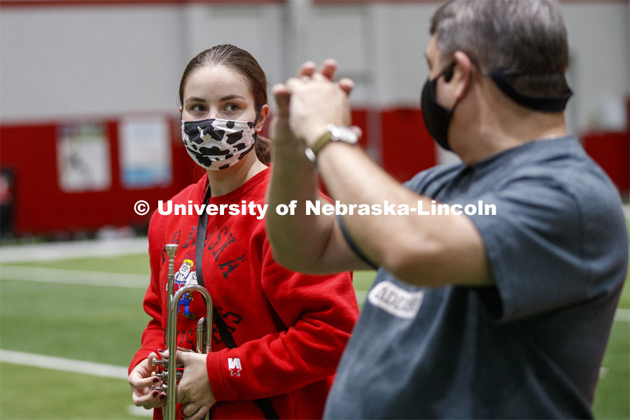 Audrey Fraser receives instruction from Tony Falcone, the Associate Director of Bands. Band members have used ingenuity to cover their horn's bell. One third of the marching band meets each morning at Cook to practice as the rest of the band practices in other locations where they can properly distance. Cornhusker Marching Band practice in Cook Pavilion. September 10, 2020. Photo by Craig Chandler / University Communication.