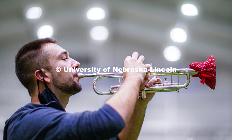 Nate Iverson plays his trumpet under the lights--of Cook Pavilion. One third of the marching band meets each morning at Cook to practice as the rest of the band practices in other locations where they can properly distance. Cornhusker Marching Band practice in Cook Pavilion. September 10, 2020. Photo by Craig Chandler / University Communication.