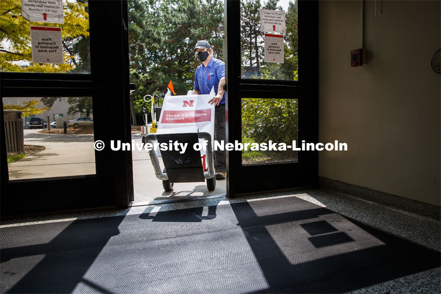 Brent Clabaugh, Zone Preventive Maint Associate with Facilities, wheels a large sanitizer dispenser back into Hamilton Hall. The large dispensers are refilled outdoors for safety reasons. September 15, 2020. Photo by Craig Chandler / University Communication