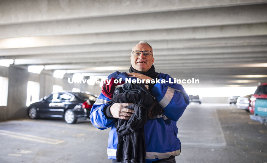 Kirk McManus with Parking and Transit Service holds clothing items he's collected for his monthly drives for the People's City Mission. The project is inspired by McManus' childhood, which included helping his parents get out of a debt rut. His UNL work is keeping the parking garage gates and mechanisms working. November 12, 2020. Photo by Craig Chandler / University Communication.