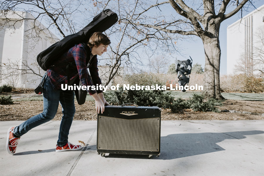 Brock Godown, a freshman from Geneva, rolls his amplifier back to his residence hall following a music class in Westbrook Music Building. November 16, 2020. Photo by Craig Chandler / University Communication.