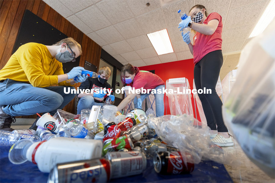 Students check the recycle labels on bottles from Hardin Hall. Environmental Studies Orientation students work on a waste audit of Hardin Hall, Ag Hall, and Filley Hall as part of a class project.  March 24, 2021. Photo by Craig Chandler / University Communication  The waste audit is part of a community engagement assignment for students in Environmental Studies Orientation (ENVR 101). It will entail 11 undergraduate students collecting waste from the new recycling containers on East Campus. After collecting the waste, students will sort the waste into piles to be diverted to landfill and recycling. They will measure and record the weight of the waste. This is the first time the waste stream is being audited using the new recycling containers. The data students collect will be used for a baseline assessment of how the new recycling pilot program is working. 