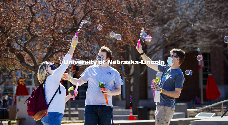 Samantha Moore, William Roarty and Jace Armstrong let the wind do the work as they blow bubbles outside the Nebraska Union. Students have fun at the Spring Breakout, a midday festival with free games, music, and prizes. 300 free t-shirts for participants. March 29, 2021. Photo by Craig Chandler / University Communication.