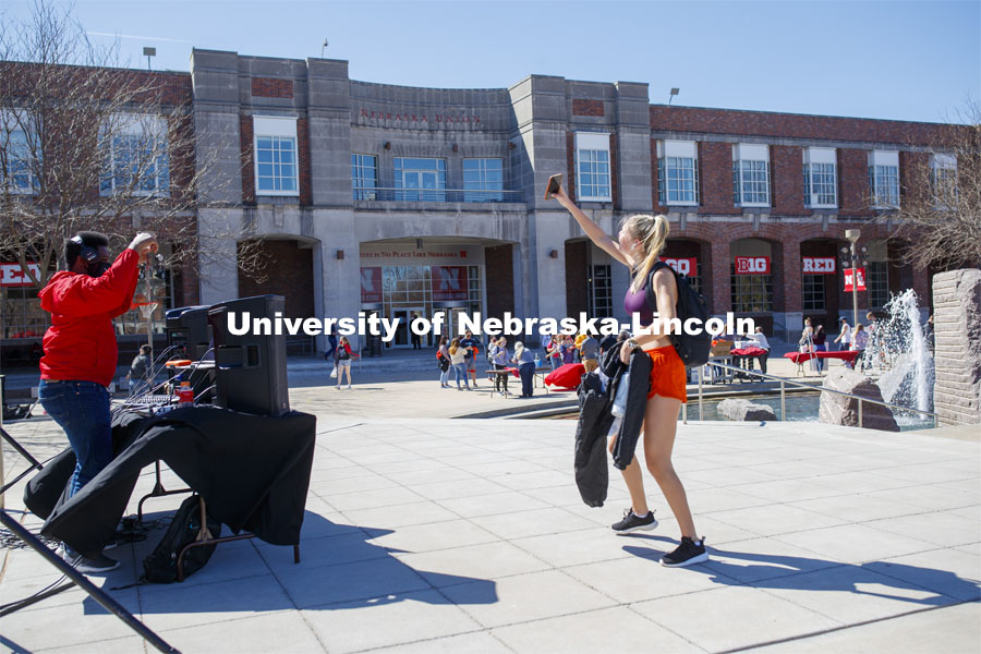 A young woman takes a selfie outside the Nebraska Union. Students have fun at the Spring Breakout, a midday festival with free games, music, and prizes. 300 free t-shirts for participants. March 29, 2021. Photo by Craig Chandler / University Communication.