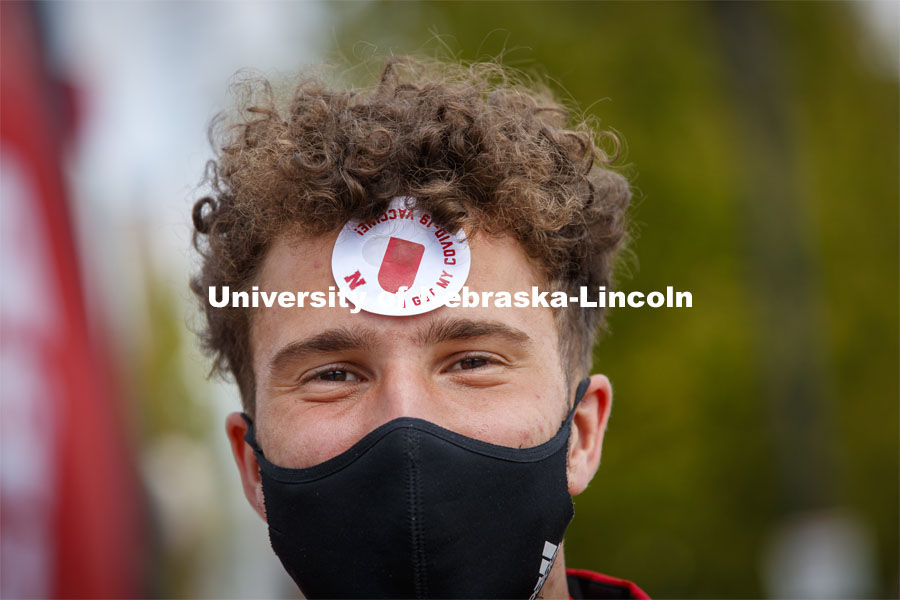 Albert Sprlak wears his sticker after being vaccinated Tuesday. Vaccine clinic in the Coliseum with a free food and goodies tent outside. April 20, 2021. Photo by Craig Chandler / University Communication.