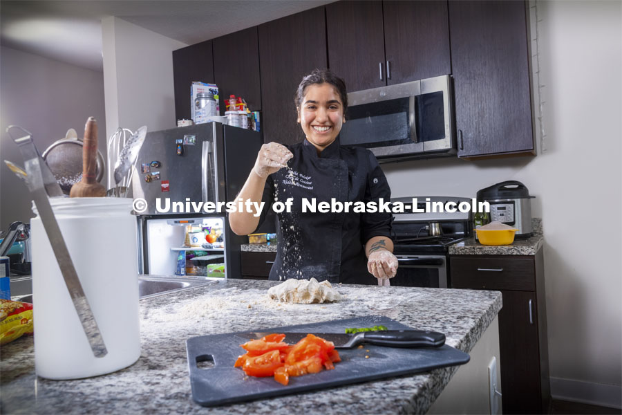 Nidhi Polekar, a triple major in Political Science, English, and Film Studies. She is pictured cooking in her kitchen. ASEM recruitment feature story. May 3, 2021. Photo by Craig Chandler / University Communication.  