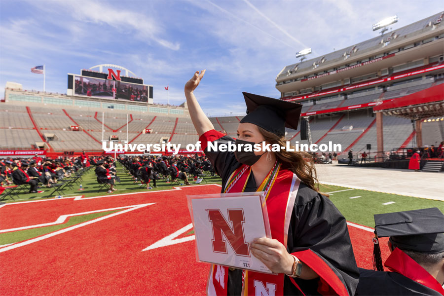 Karlie Sines waves to family and friends after receiving her Fine and Performing Arts degree. UNL Commencement in Memorial Stadium. May 8, 2021. Photo by Craig Chandler / University Communication.