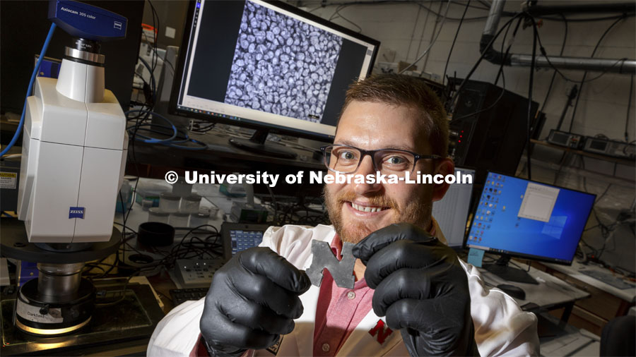 Eric Markvicka, Assistant Professor in Mechanical and Materials Engineering, holds a rubber-like “N” embedded with liquid metal droplets that themselves contain glass microparticles, Markvicka's team has improved the material's thermal conductivity while retaining its natural pliability. That could make the approach useful in engineering wearable technologies and soft robotics that can shed the excess heat produced by their microelectronics — reducing the risk of overheating — while remaining lightweight and elastic enough for practical use. November 4, 2021. Photo by Craig Chandler / University Communication