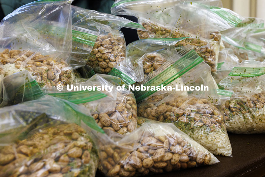 Packaged meals pile up awaiting instructions that will be taped to each bag. Volunteers are packing more than 2,000 rice and bean meals that will be distributed to feed the hungry across Nebraska. MLK Volunteers dish up meals for the Food Bank of Lincoln in the Nebraska Union. January 19, 2022. Photo by Craig Chandler / University Communication.