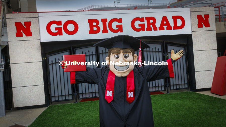 Herbie Husker in cap and gown to promote 2022 spring commencement in Memorial Stadium. May 4, 2022. Photo by Craig Chandler / University Communication.