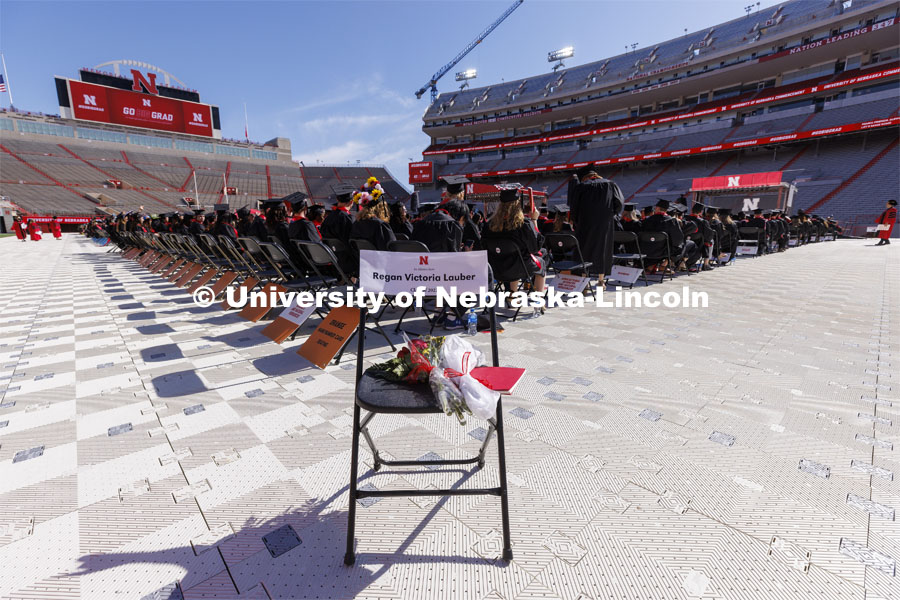 A chair with flowers and a program was in the corner of Memorial Stadium in honor of Regan Lauber who was killed in a plane crash on March 17, 2022. UNL undergraduate commencement in Memorial Stadium. May 14, 2022. Photo by Craig Chandler / University Communication.