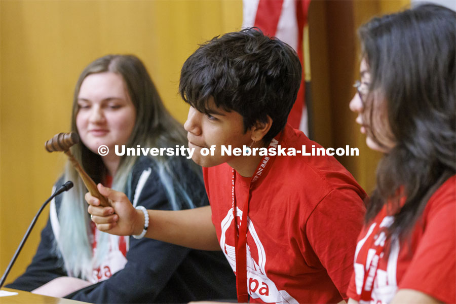 Melaki George of Winnebago High School tries to gavel the courtroom back to order as he presides with two other judges over the trial of Goldilocks vs the Three Bears. NCPA junior and senior high school students participate in a mock trial at Nebraska Law. June 9, 2022. Photo by Craig Chandler / University Communication.