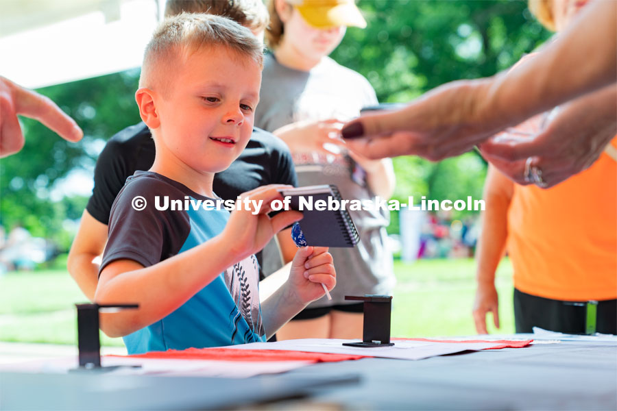 A Discovery Day attendee wins a notebook. The East Campus Discovery Days and Farmer’s Market at UNL is a fun, family-friendly event for all ages. It’s more than a farmer’s market. It’s more than a science day. Come for the hands-on, science-focused fun. Stay to enjoy live music and food trucks. Shop at our farmer’s market and vendor fair. June 11, 2022. Photo by Jordan Opp / University Communication.