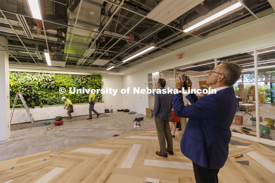 Chancellor Ronnie Green takes a photo of a living wall in the new wellness area of the law library. The hydroponic wall is made of living plants. Green and donors take a tour of the renovated College of Law library. The $6 million renovation of the Marvin and Virginia Schmid Law Library began in May 2021 will be open in the fall. The project will provide new and rejuvenated spaces for the community. June 22, 2022. Photo by Craig Chandler / University Communication.