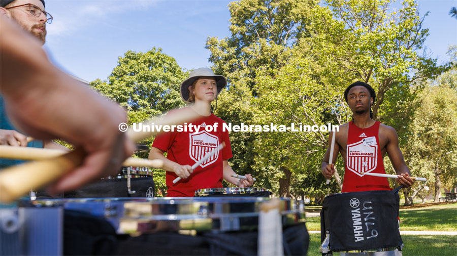 The Cornhusker Marching Band percussion groups kick off the school year. Snares, from left, Joel Williams, Brynn Boes and Tamario Brooks practice under a shade tree in front of Architecture Hall. Drum line practice on the first day of Cornhusker Marching Band camp. August 11, 2022. Photo by Craig Chandler / University Communication.