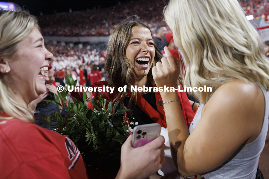 Newly crowned homecoming royalty Emily Hatterman is surrounded by friends Malori Grabast, left, and Willa Scoville as she leaves the field. Nebraska vs. Indiana football Homecoming game. October 1, 2022. Photo by Craig Chandler / University Communication.