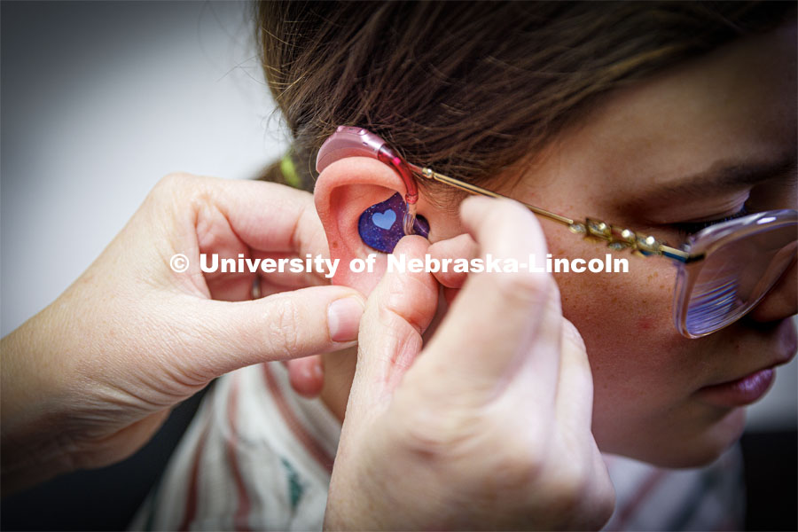 Audiologist Stacie Ray checks the ears and hearing aids of 13-year-old Chloie Lechance in the Barkley Clinic. Chloie has been a patient of Stacie Ray's for years. October 21, 2022. Photo by Craig Chandler / University Communication.