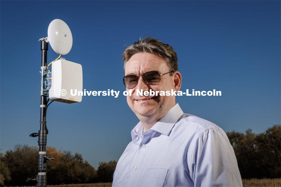 Mehmet Can Vuran lead member of the Field-Nets research team poses in a soybean field on east campus field with a Millimeter-wave (mmWave) radio with phased-array antennas. October 28, 2022. Photo by Craig Chandler / University Communication.