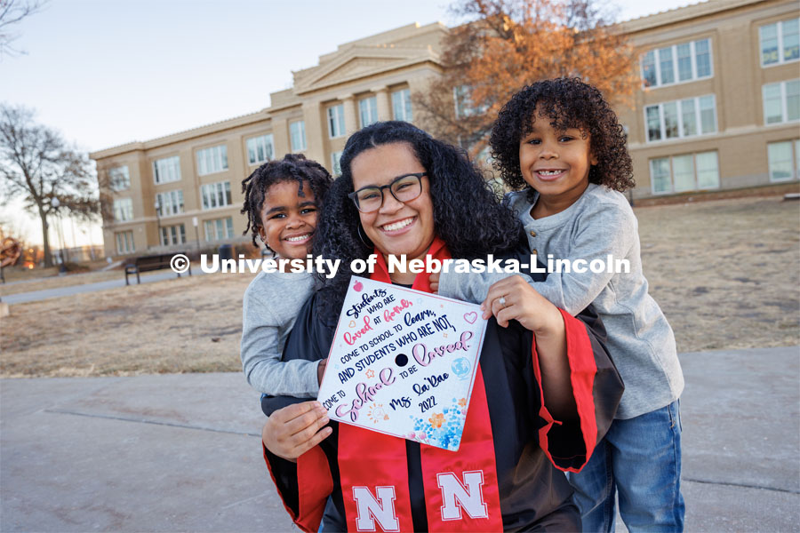 La’Rae Pickens-Bonebright with her sons Amarien, 6, and JJ, 4. In the background stands Lincoln High School, which Pickens-Bonebright attended while carrying each of the boys. Pickens-Bonebright will graduate with her bachelor’s in elementary education and early childhood education. December 1, 2022. Photo by Craig Chandler / University Communication.