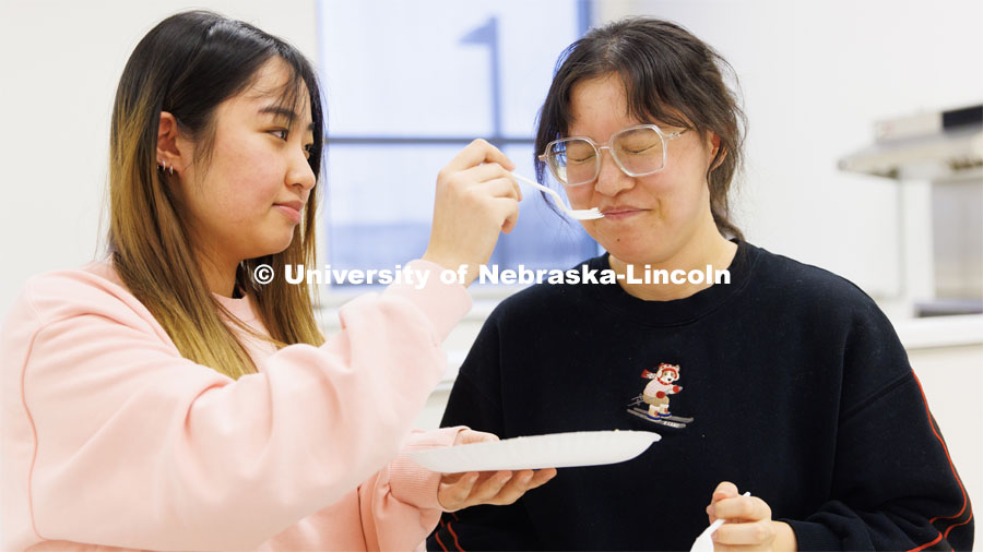 Zhuo Chen wrinkles her nose after smelling a cheese sample held by Baoyue Zhang. Heather Hallen-Adams teaches FDST 492 - Special Topics in Food Science and Technology topic Moldy Meals: Koji and More. January 10, 2023. Photo by Craig Chandler / University Communication.