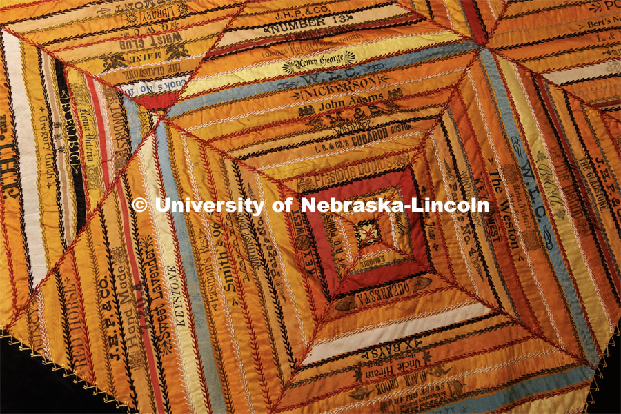 A quilt made from cigar ribbons.  The ribbons are made of silk and used to tie quantities of cigars together when packaging and shipping them.  The ribbons have been used since the late 1800s. Quilt Center. February 8, 2023. Photo by Craig Chandler / University Communication.