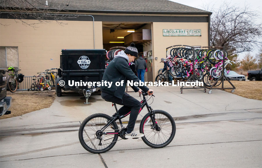 Jacob Dalton test rides a bike outside the Lincoln Bike Kitchen after making a repair. Lincoln Bike Kitchen organizers have set an annual goal of giving away 1,000 bikes to area youth and adults in need. The Bike Kitchen is among a number of local organizations that the College of Engineering works with to offer service learning opportunities to its students. March 9, 2023. Photo by Dillon Galloway for University Communication.