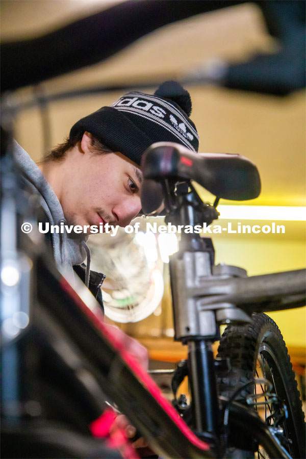 Engineering student Jacob Dalton works on repairing a bike in Lincoln Bike Kitchen Repair. The Bike Kitchen is among a number of local organizations that the College of Engineering works with to offer service learning opportunities to its students. March 9, 2023. Photo by Dillon Galloway for University Communication.