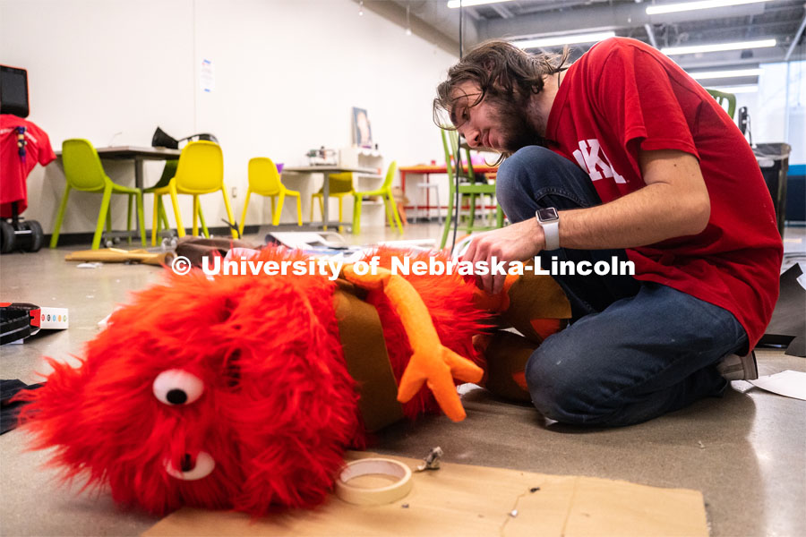 Sophomore emerging media arts major Isaiah Griffith glues foam onto the feet of a puppet for his final project at the Johnny Carson Center for Emerging Media Arts. April 9, 2023. Photo by Jordan Opp for University Communication.