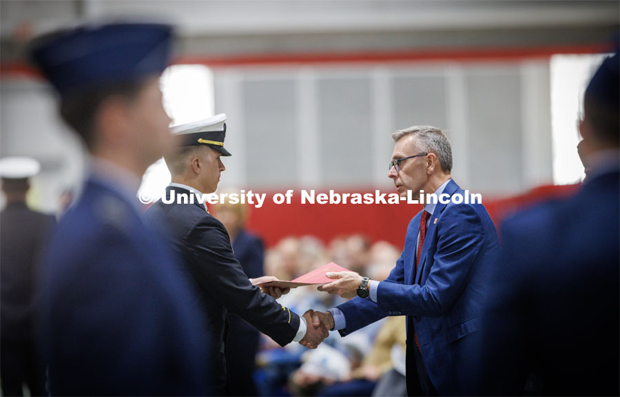 Chancellor Ronnie Green presents the Chancellor’s Academic Excellence Award to Midshipman Colin Harju. Six ROTC members were given the award at the ROTC Joint Service Chancellor’s Review in Cook Pavilion.  April 27, 2023. Photo by Craig Chandler / University Communication.