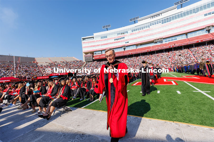 Chancellor Ronnie Green points to the camera as he walks down the aisle to give his last commencement speech as Chancellor of the University of Nebraska. Undergraduate commencement at Memorial Stadium. May 20, 2023. Photo by Craig Chandler / University Communication.