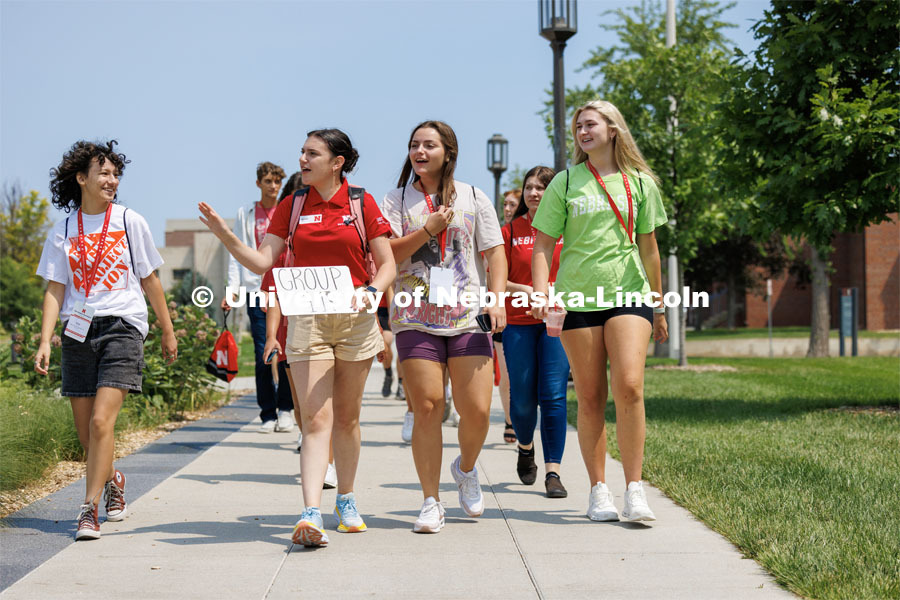 Orientation Leader Maddie Ames leads her NSE group toward Andersen Hall as they tour the journalism college. New Student Enrollment ( NSE ) on City Campus. June 13, 2023. Photo by Craig Chandler / University Communication.
