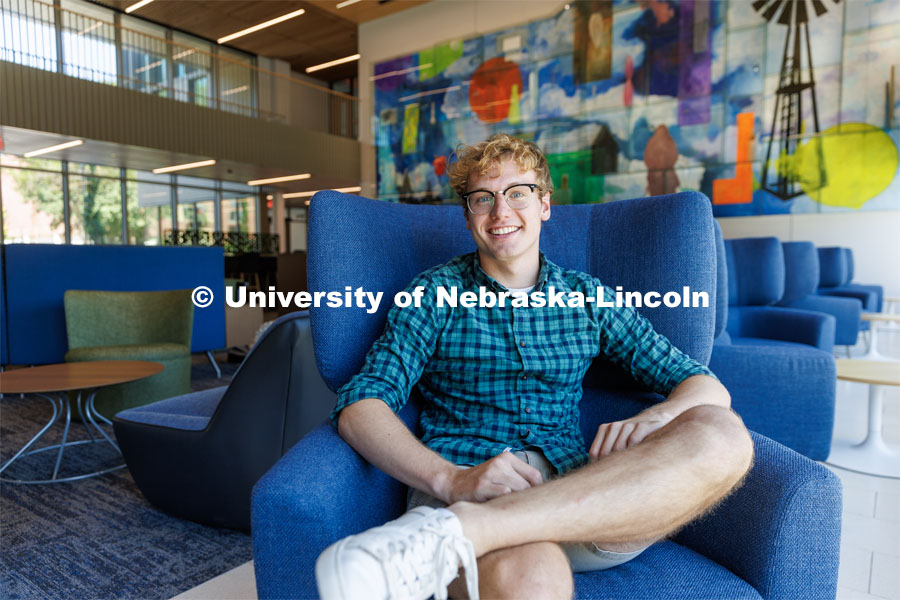 Paul Pechous, ASUN President is photographed sitting in a blue chair in the lobby of Carolyn Pope Edwards Hall. July 26, 2023. Photo by Matthew Strasburger / University Communication.