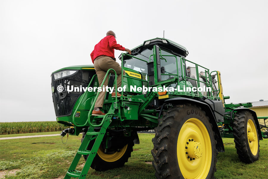 Chancellor Rodney Bennett climbs up on a John Deere sprayer that uses cameras and computers to only spray the weeds. The sprayer was being demonstrated at the South Central Ag Lab field day for area farmers. IANR Roads Scholar Tour through Nebraska. August 1, 2023. Photo by Craig Chandler / University Communication.